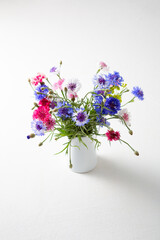 Close up of summer cornflowers in white jug