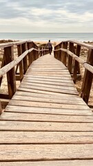 man watching the beach from wooden path