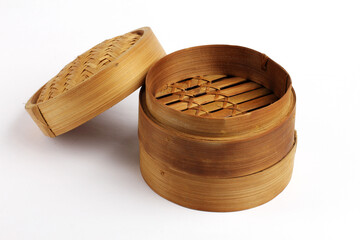 Traditional bamboo basket oriental dimsum steamer with lid and two base, on white background photo.