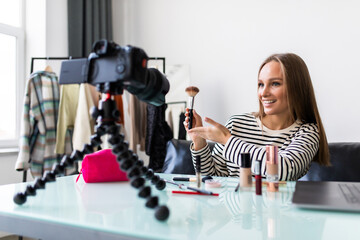 Young woman and professional beauty make up artist vlogger or blogger recording makeup tutorial to share on website or social media.