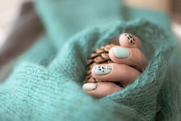 Creative cow painted on a nail. Playful and fully gel polish design ideas of summer. Cozy view of manicure. Selective focus on the details, blurred background.