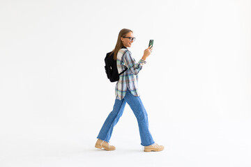 Photo of excited student woman wearing cap and earphones smiling at smartphone isolated over white background