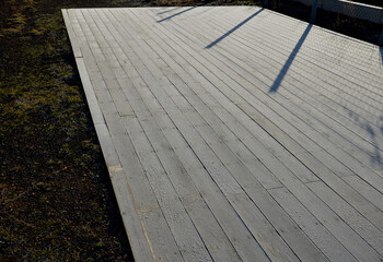 tropical wood plank ramp with wheelchair specially adapted for wheelchairs. Metal guide rails for...