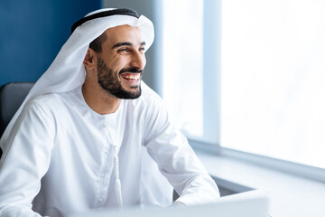 handsome man with dish dasha working in his business office of Dubai. Portraits of a successful businessman in traditional emirates white dress. Concept about middle eastern cultures - obrazy, fototapety, plakaty