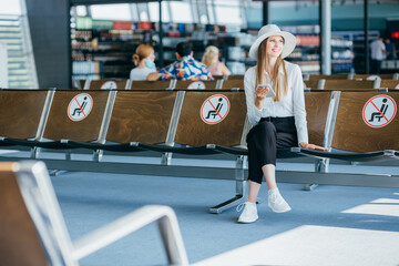 Woman on smartphone,waiting boarding time in terminal,use travel app,smiling.Travel vacations concept.