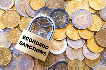 Padlock with "economic sanctions" text next to money. Economic sanctions, economic retaliation against the war. 
