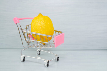 Lemon in the grocery cart. Rising food prices. Photo with an empty place for an inscription.