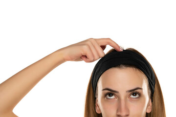 half portrait of a young woman with headband scratching her head