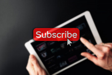 Subscription plan. Red online video subscribe button. Internet service on laptop digital tablet blured technology background. Visual contents concept. Social networking service.