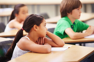Wishing they could play outside. Scholars sitting in a classroom looking bored.