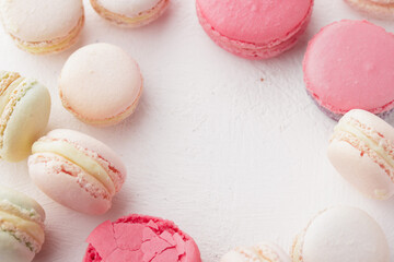 Pastel colored macaroons on a white background with copyspace