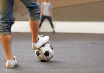 Ready to score. Cropped image of a mans foot on a soccer ball in the street.