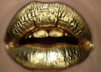 Obraz premium Golden lipstick closeup. Lips with metal makeup.
