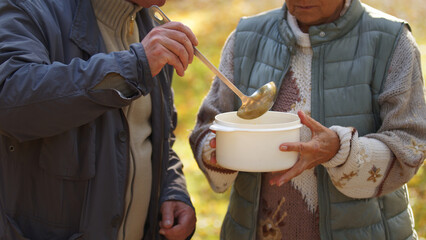 Two caucasian people sharing soup with each other. Helping people in need concept. High quality photo