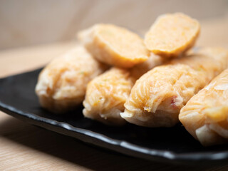 Stack of shrimp egg rolls on a black square bowl