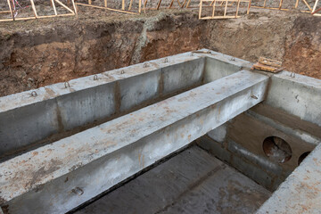 Installation of reinforced concrete beams for water supply and sewerage at the construction site. Thermal unit for the distribution of water and sewerage in the city.