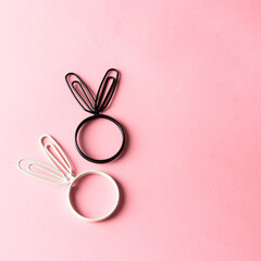 Bunny bunny ears in black and white color on pink background. Minimalist Easter  concept.