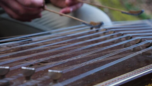 A close-up of a street musician playing a musical instrument, the cimbalom. Traditional musical instrument of the peoples of Eastern Europe