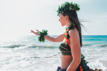 Gorgeous woman dressed in traditional Hawaiian dance attire enjoying views of a spectacular paradise beach