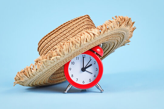 Concept for summer daylight saving time in Europe with alarm clock with straw hat