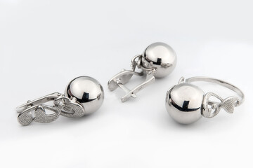 Silver jewelry set of ring and silver earrings with stones on white background. Silver jewelry set...