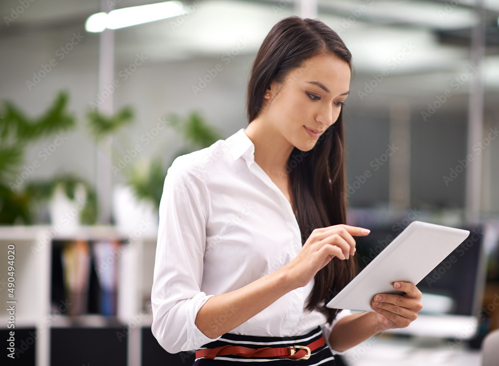 Poster working is easy when my office is in my hand. cropped shot of an attractive young woman using a digi