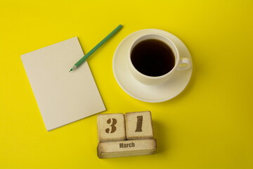 coffee with a notebook and the date of March 31 on a yellow background