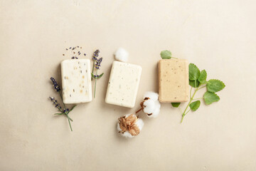 Natural soap bars and ingredients- lavender, cotton, patchouli - on natural stone background, flat lay - obrazy, fototapety, plakaty