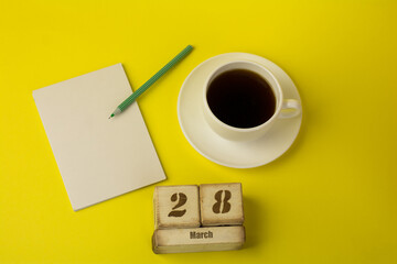 coffee with a notebook and the date of March 28 on a yellow background