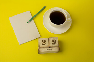 coffee with a notebook and the date of March 29 on a yellow background