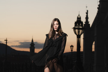 Beautiful female model in summer city in Europe. Trendy woman posing on night city street in Budapest.