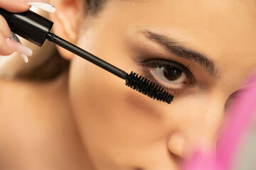 Close up of woman applying mascara on the lower eyelashes