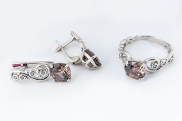 Elegant jewelry set of white gold ring, necklace and earrings with diamonds. Silver jewellery set with gemstones. Product still life concept