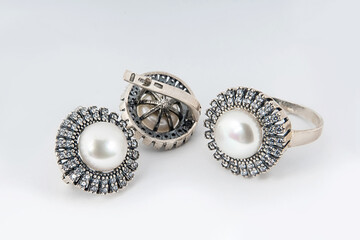 Elegant jewelry set of white gold ring, necklace and earrings with diamonds. Silver jewellery set with gemstones. Product still life concept