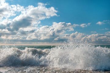A white foamy splashing waves with blue cloudy sky background