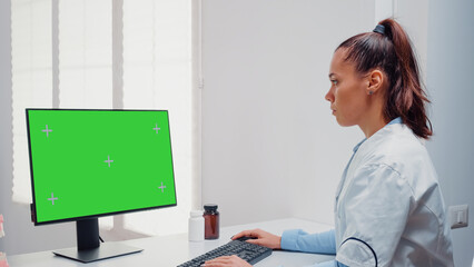 Obraz na płótnie Canvas Dentist working with horizontal green screen on computer for teethcare at dental office. Woman using keyboard and monitor with chroma key for mockup template and isolated background
