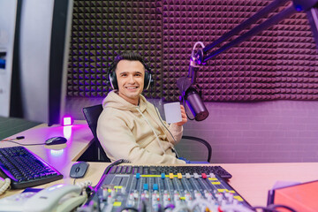 funny emotional radio host with headphones drinking tea on fun live streaming