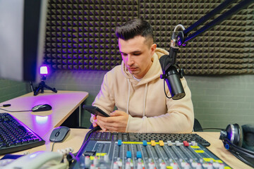 a radio host with phone during break on a broadcast in a radio studio. 