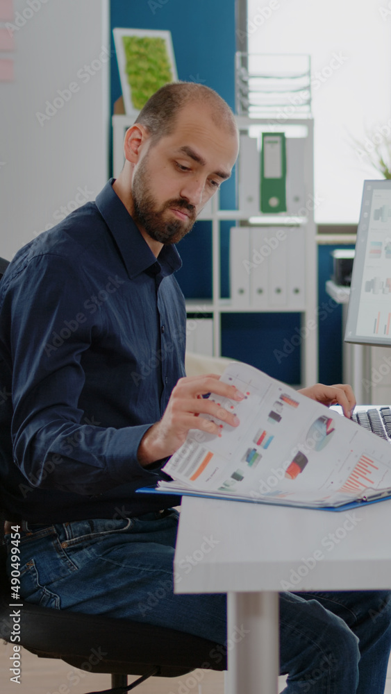 Poster business manager using computer and papers with charts for marketing strategy. entrepreneur with cor