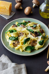Linguini pasta with mushrooms, spinach and cheese. Healthy eating. Vegetarian food. Italian cuisine.