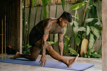 Young latin american tattooed man practice yoga outdoors during retreat vacation in Bali,...