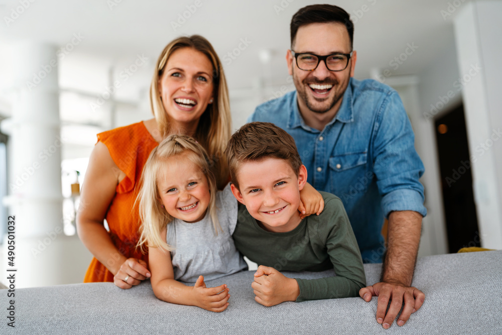 Wall mural Happy family having fun time at home. Parents playing smiling with childrens together.