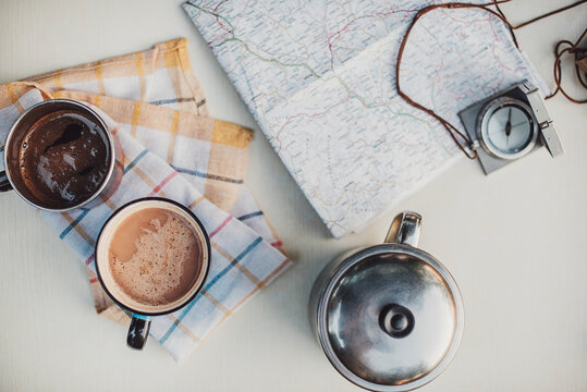 Two Mugs With Hot Drinks On The Table With Other Camping Equipment Close Up