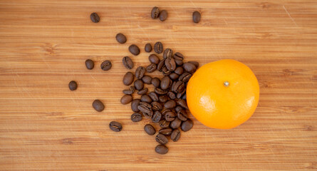 Grains de café et mandarine sur une planche en bois