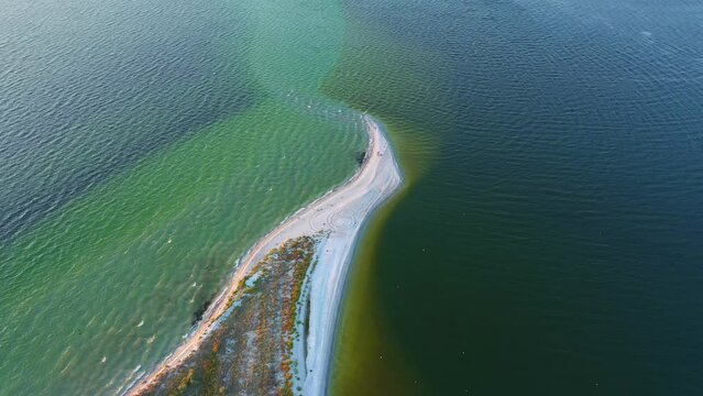 Shooting from a drone flying over a long sandy spit. Filmed in 4k, drone video.