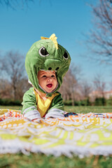 Baby dressed in a dinosaur costume