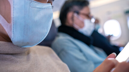 Woman passengers wearing surgical mask to prevent omicron variant at flight trip