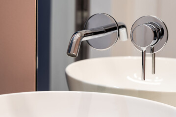 Bathroom faucet and modern bathroom bettery, coming out of the bathroom mirror above the...