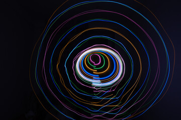 lights circles with different colour, isolated on black background. Long exposure light painting photo of abstract round form. Swirl trail effect. Picture for creative wallpaper, design art work