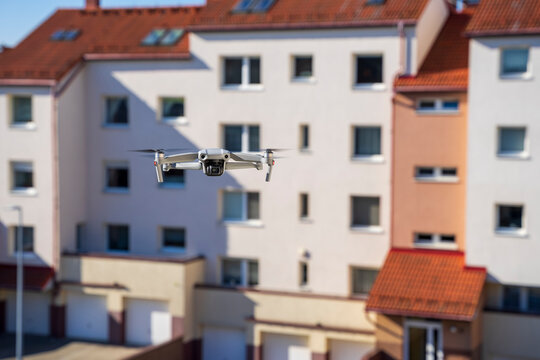Dron w mieście, dron leci wsr&oacute;d blok&oacute;w mieszkalnych.